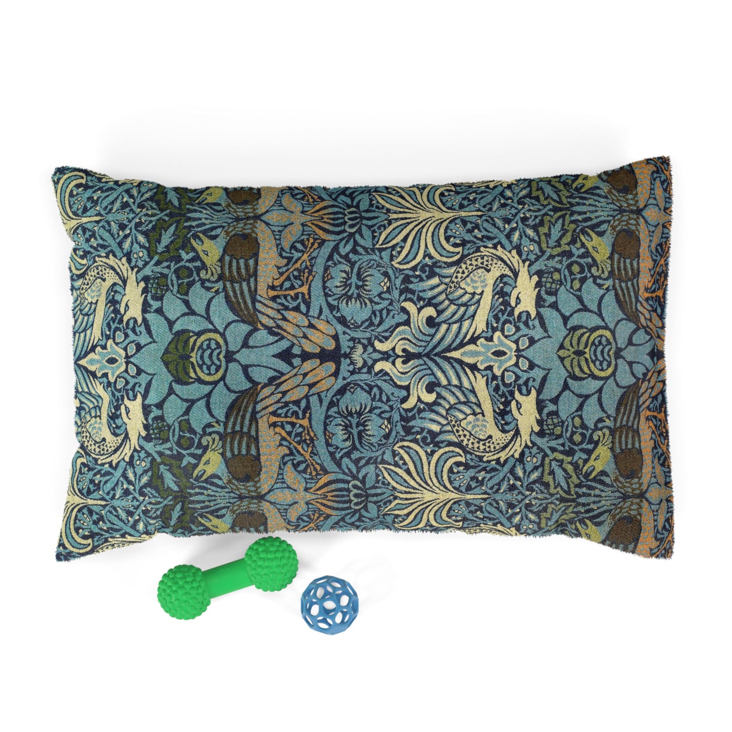 Decorative pillow with peacock pattern and two pet toys on a white background