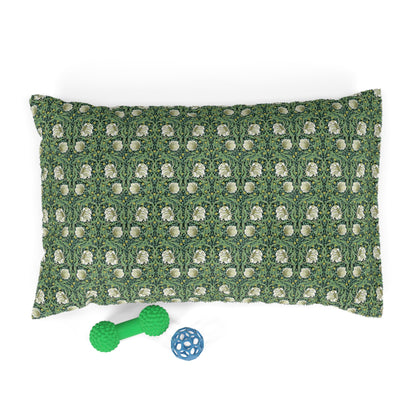 Green floral-patterned pillow with two dog toys on a white background