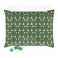Green dog pillow with white floral pattern on a white background
