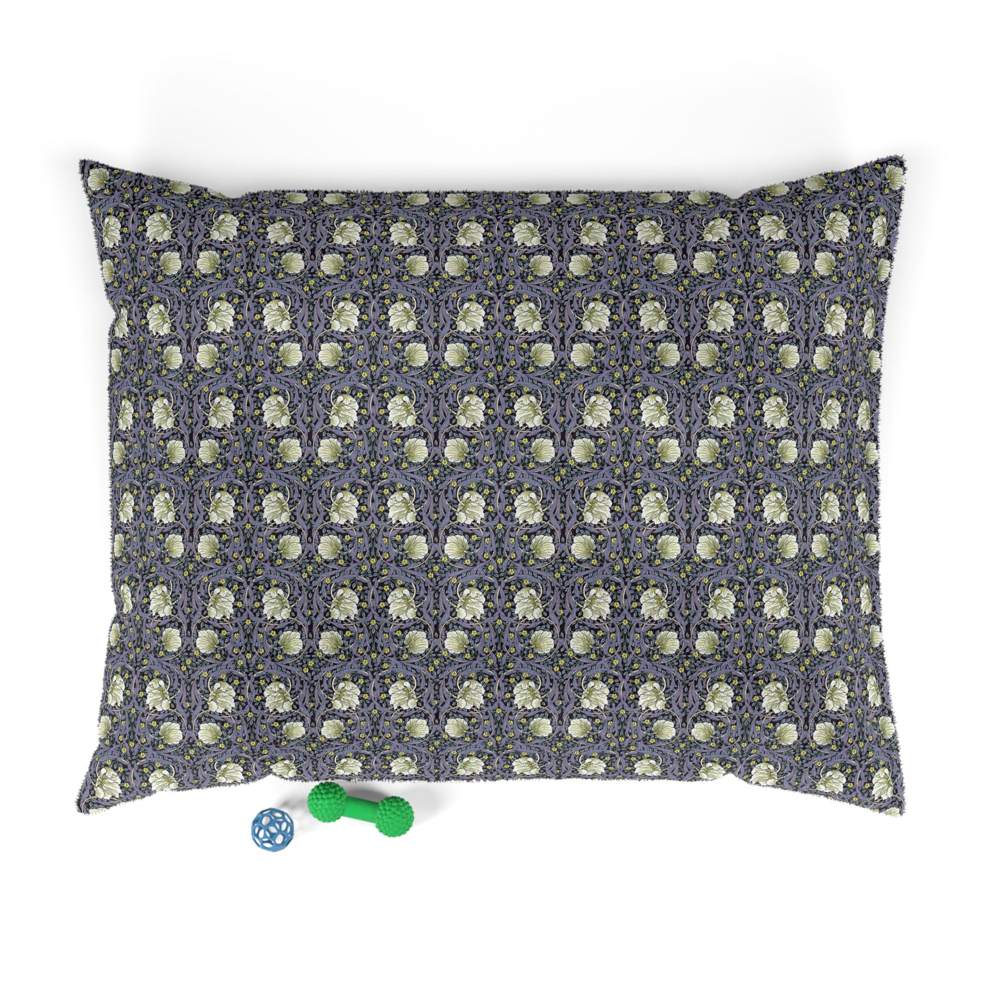 Floral patterned pet bed with two small toys on a white background