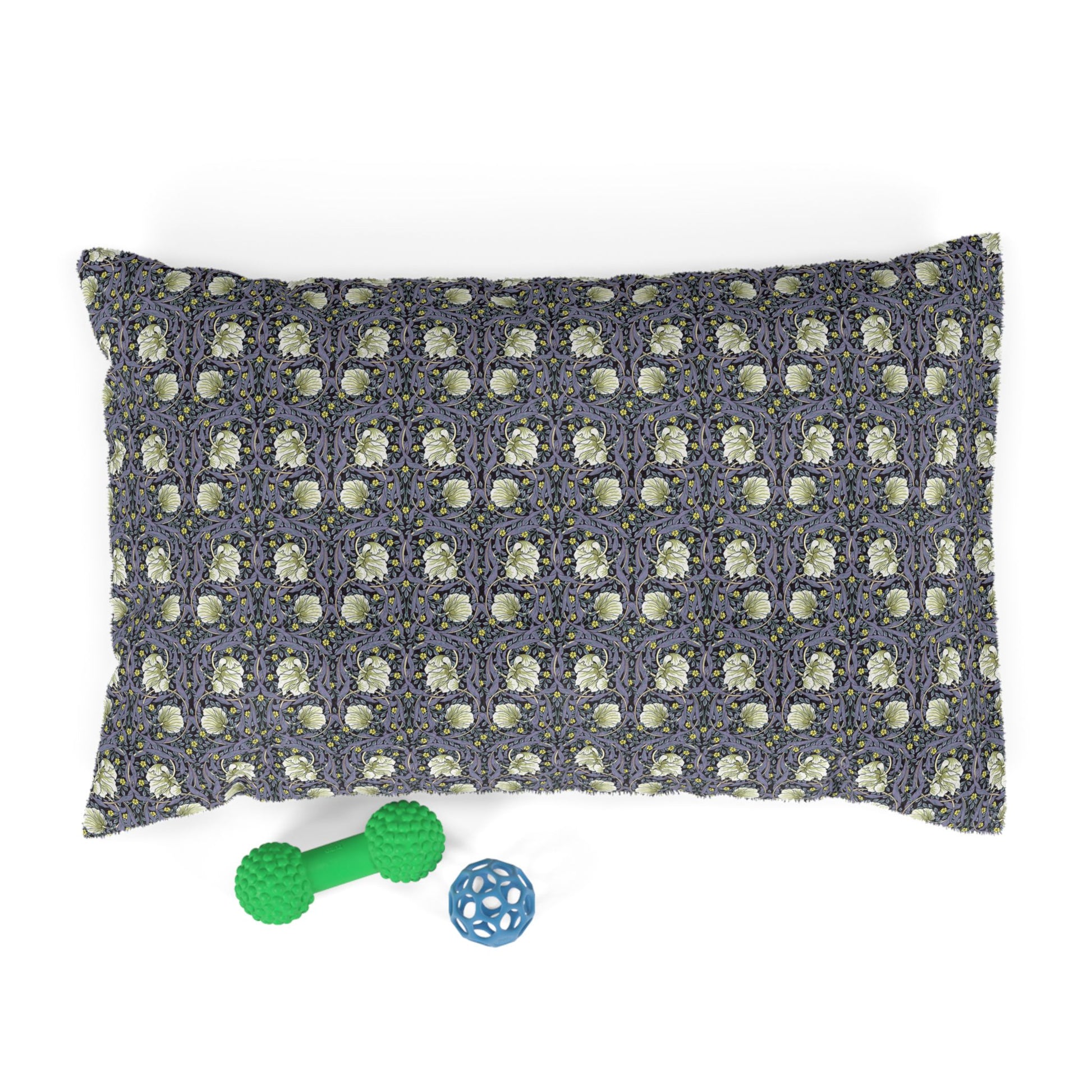 Floral-patterned dog pillow with two dog toys on a white background