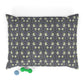 Patterned dog pillow with a small green dog toy on a white background
