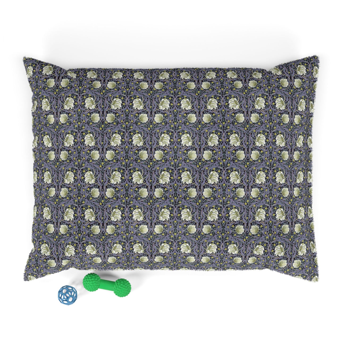 Patterned dog pillow with a small green dog toy on a white background