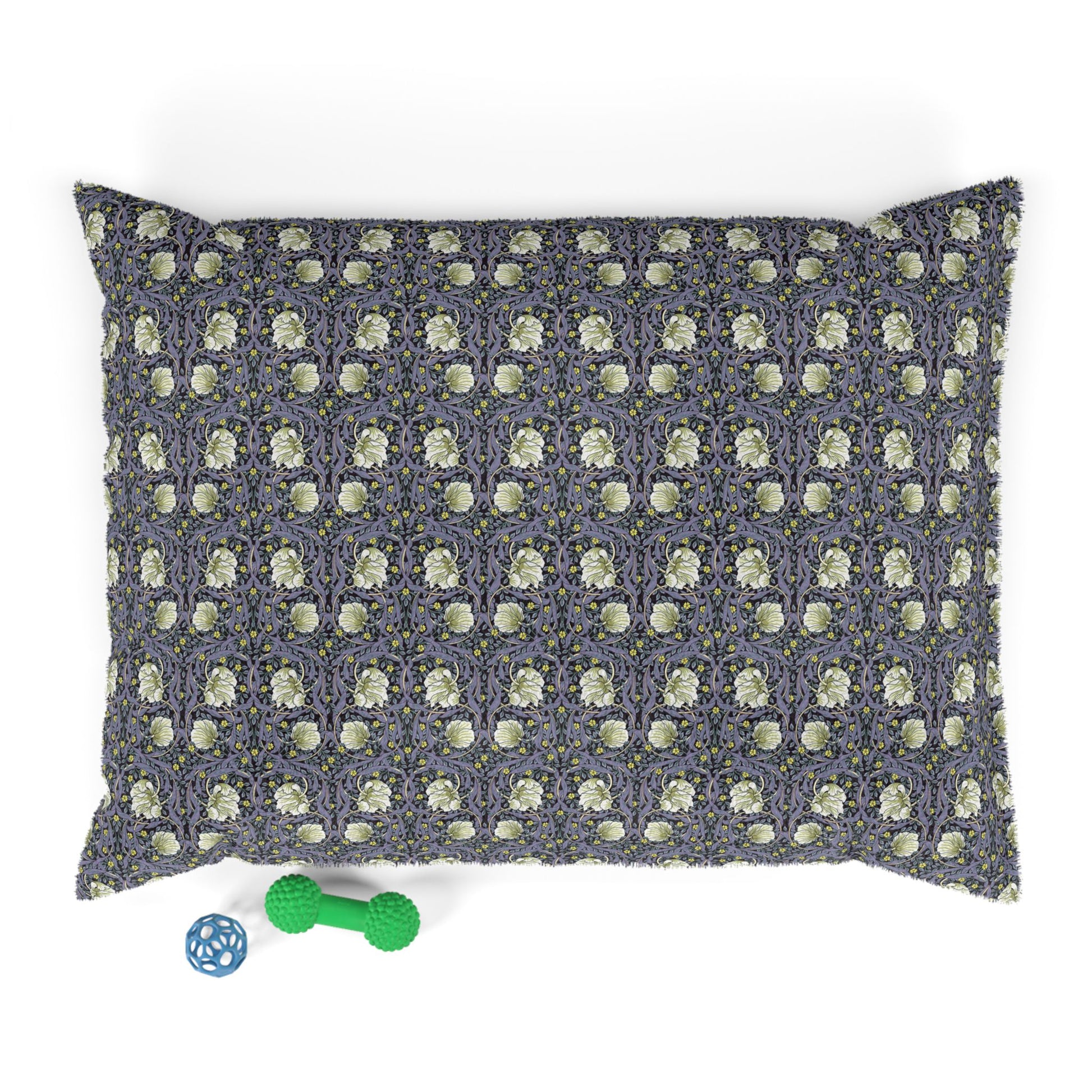 Patterned dog pillow with a small green dog toy on a white background