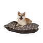 Dog sitting on a floral-patterned dog bed with a white background