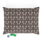 Patterned pillow with a small green and blue toy at the bottom on a white background