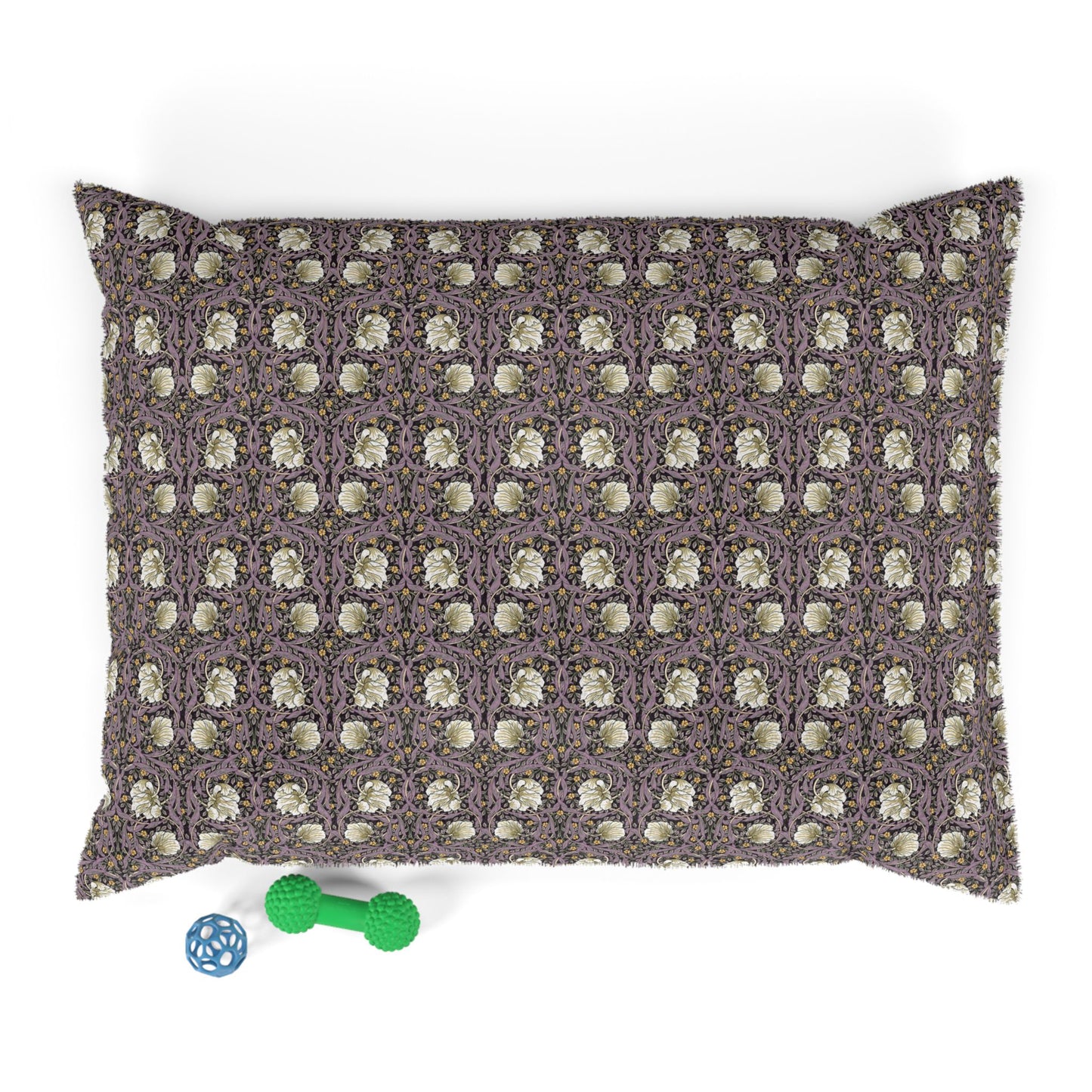 Patterned pillow with a small green and blue toy at the bottom on a white background