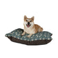 Dog lying on a William Morris & Co floral-patterned dog bed with a white background