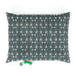Floral patterned pet bed with two dog toys on a white background
