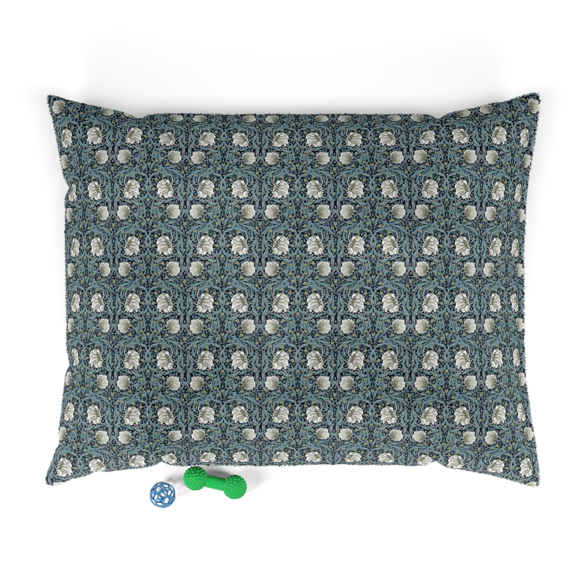 Floral patterned pet bed with two dog toys on a white background