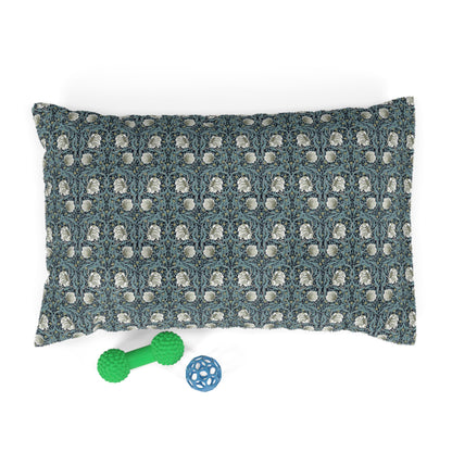 Decorative pillow with William Morris & Co floral pattern and two pet toys on a white background