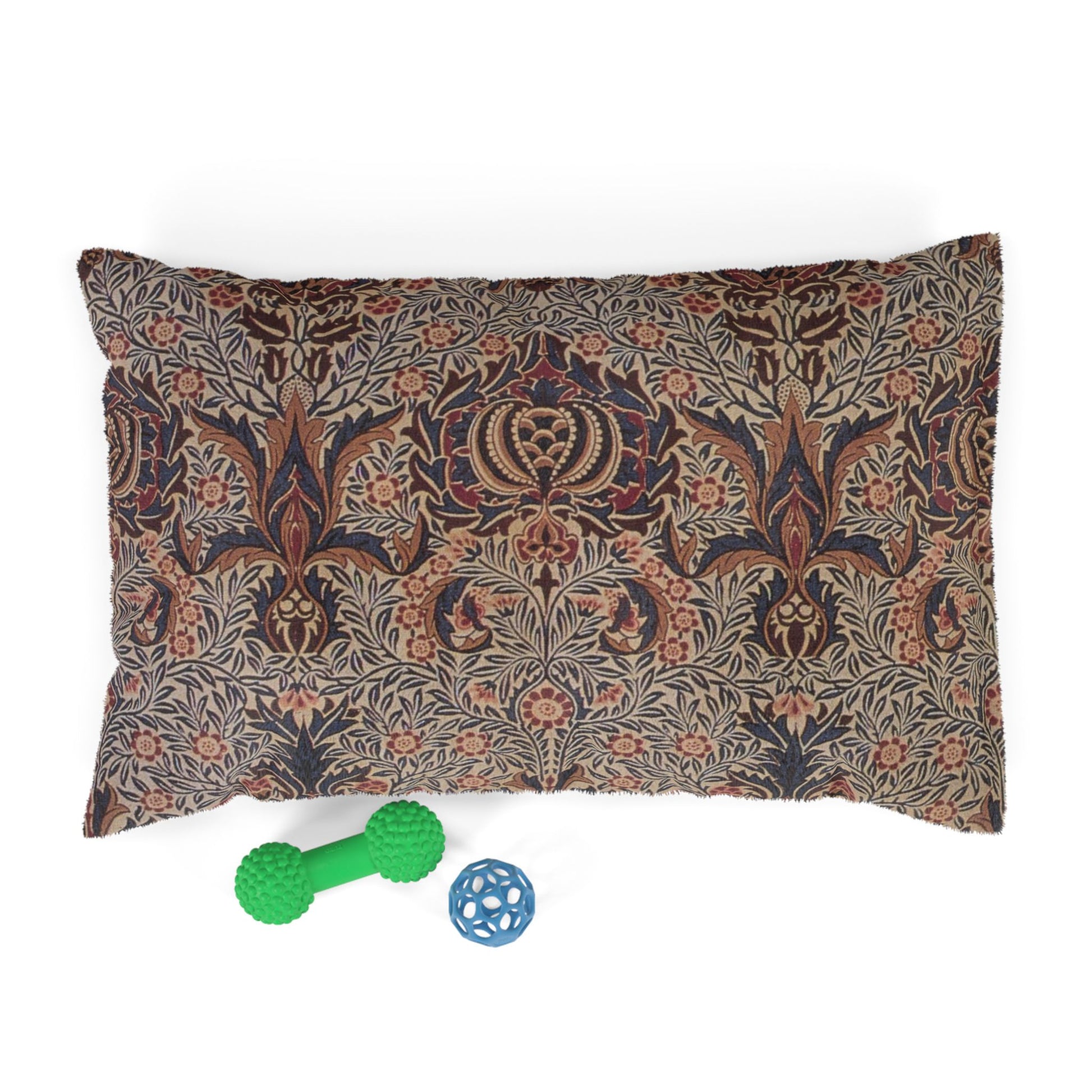 Decorative pillow with floral pattern and two dog toys on a white background