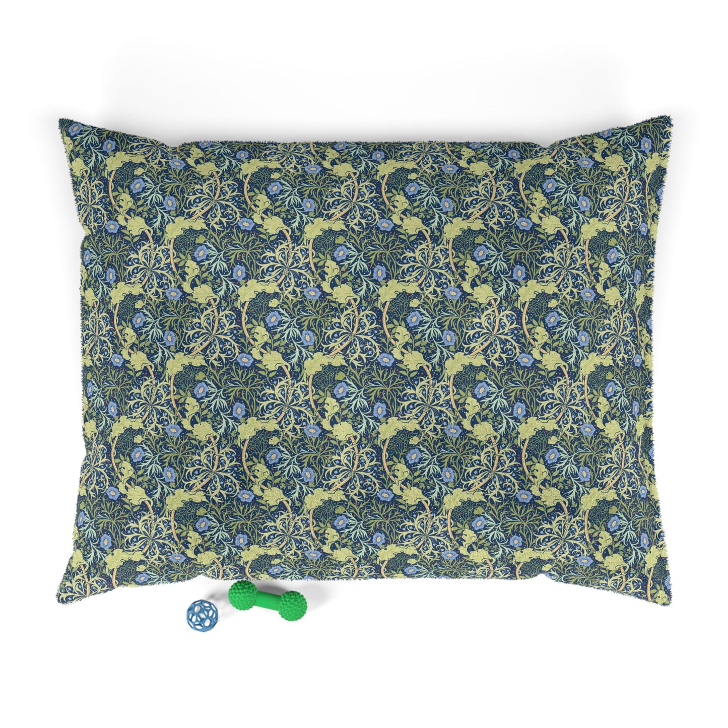 Floral patterned dog pillow with a small blue and green toy on a white background