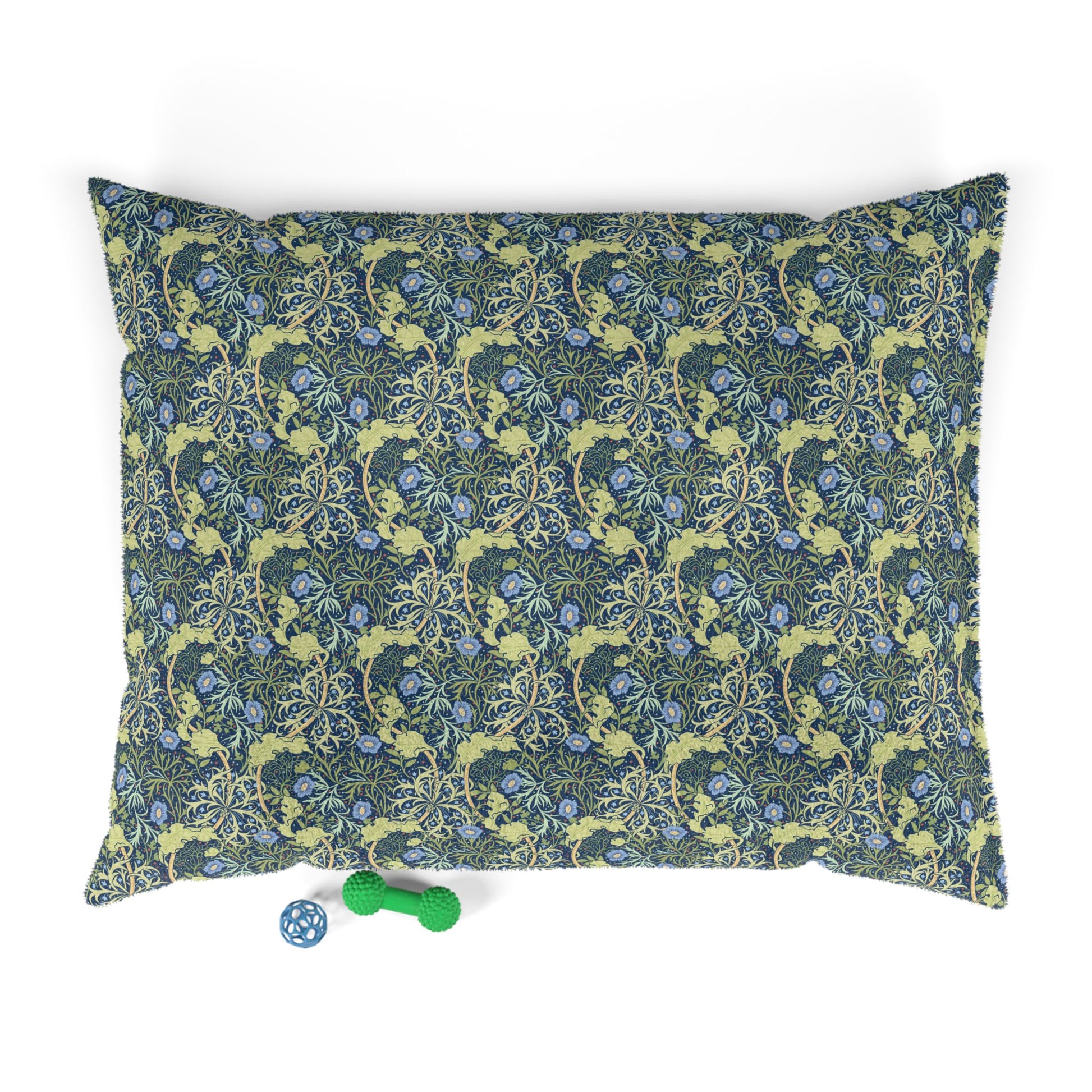 Floral patterned dog pillow with a small blue and green toy on a white background