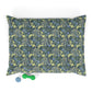 Floral patterned pillow with a green dog toy on a white background
