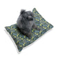 Dog sitting on a floral-patterned dog bed with a white background