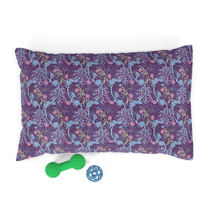 Purple pillow with William Morris & Co seaweed pattern and two green and blue dog toys on a white background