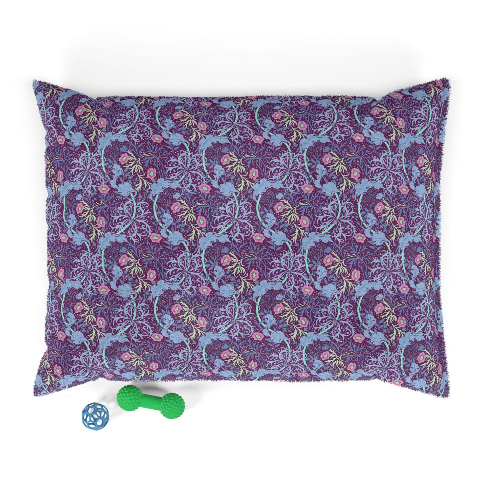 Floral-patterned dog pillow with a green and blue dog toy on a white background