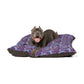 Dog lying on a purple and brown patterned dog bed with a white background