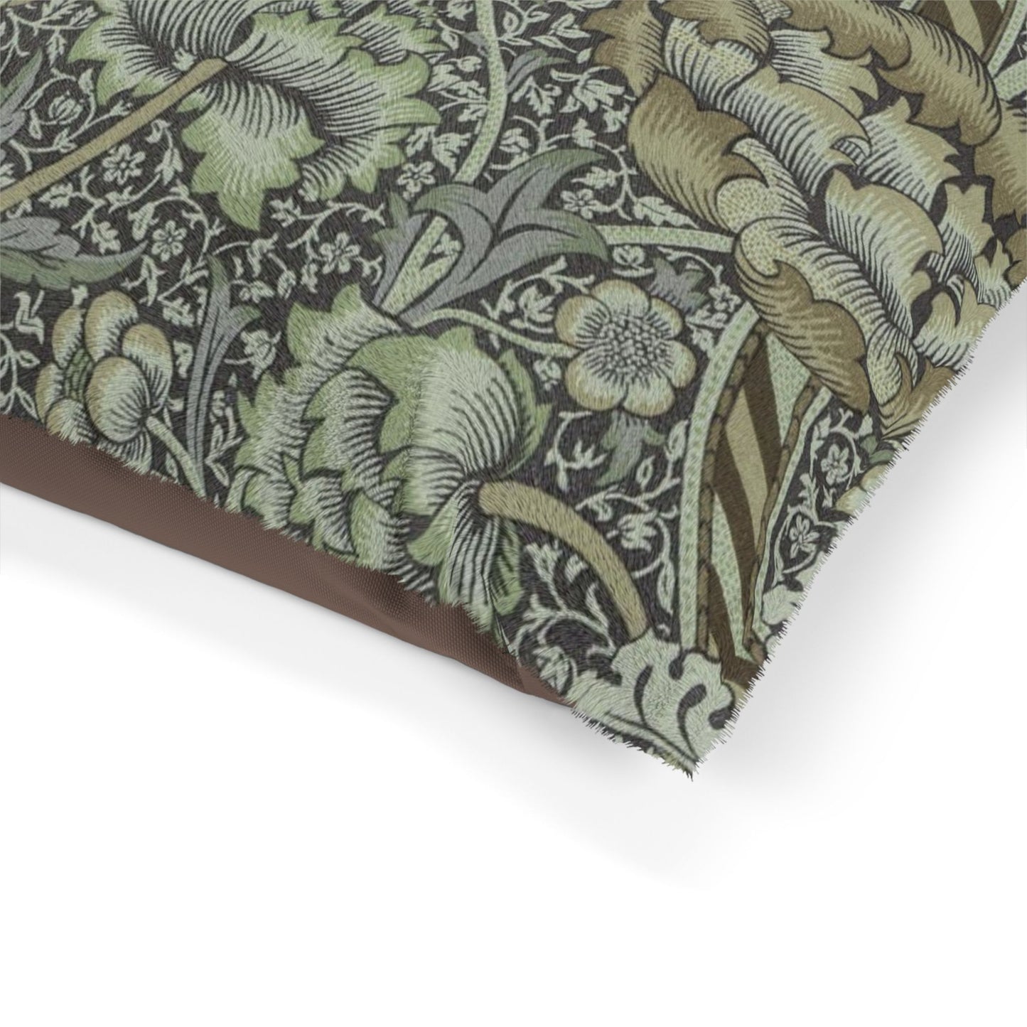 Close-up of a dog bed with intricate William Morris & Co green and brown pattern on a white background