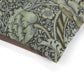 Close-up of a William Morris & Co floral patterned dog bed with green and brown colours on a white background