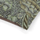 Close-up of a dog bed with intricate William Morris & Co green and brown floral pattern on a white background