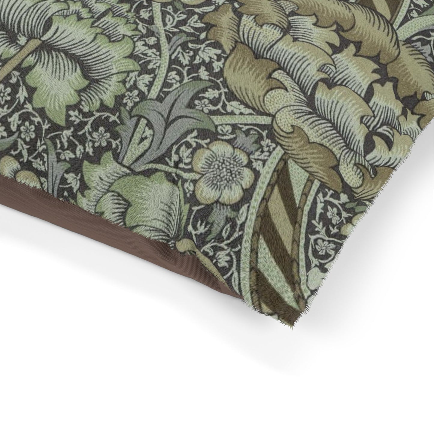 Close-up of a dog bed with intricate William Morris & Co green and brown floral pattern on a white background