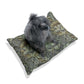 Dog sitting on a William Morris & Co floral-patterned cushion with a white background