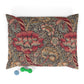 Decorative pillow with floral pattern and two dog toys on a white background