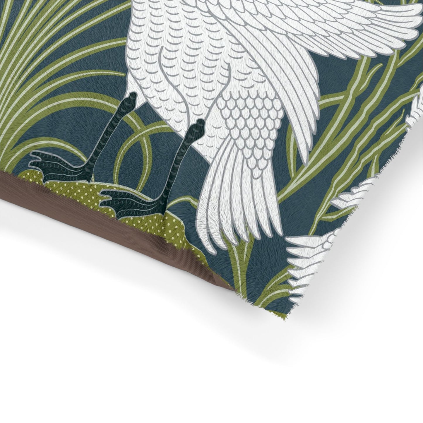 Close-up of a fabric with white bird and green leaf pattern on a dark blue background