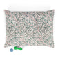 Floral patterned pet bed with a green bone-shaped toy on a white background
