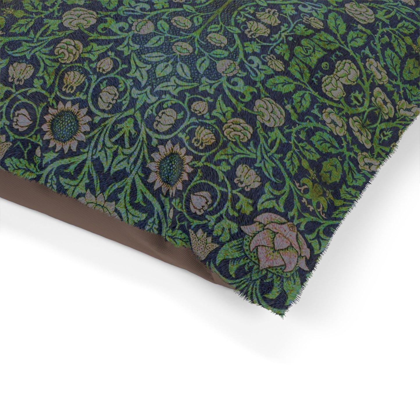Dog sitting on a William Morris & Co patterned green cushion against a white background