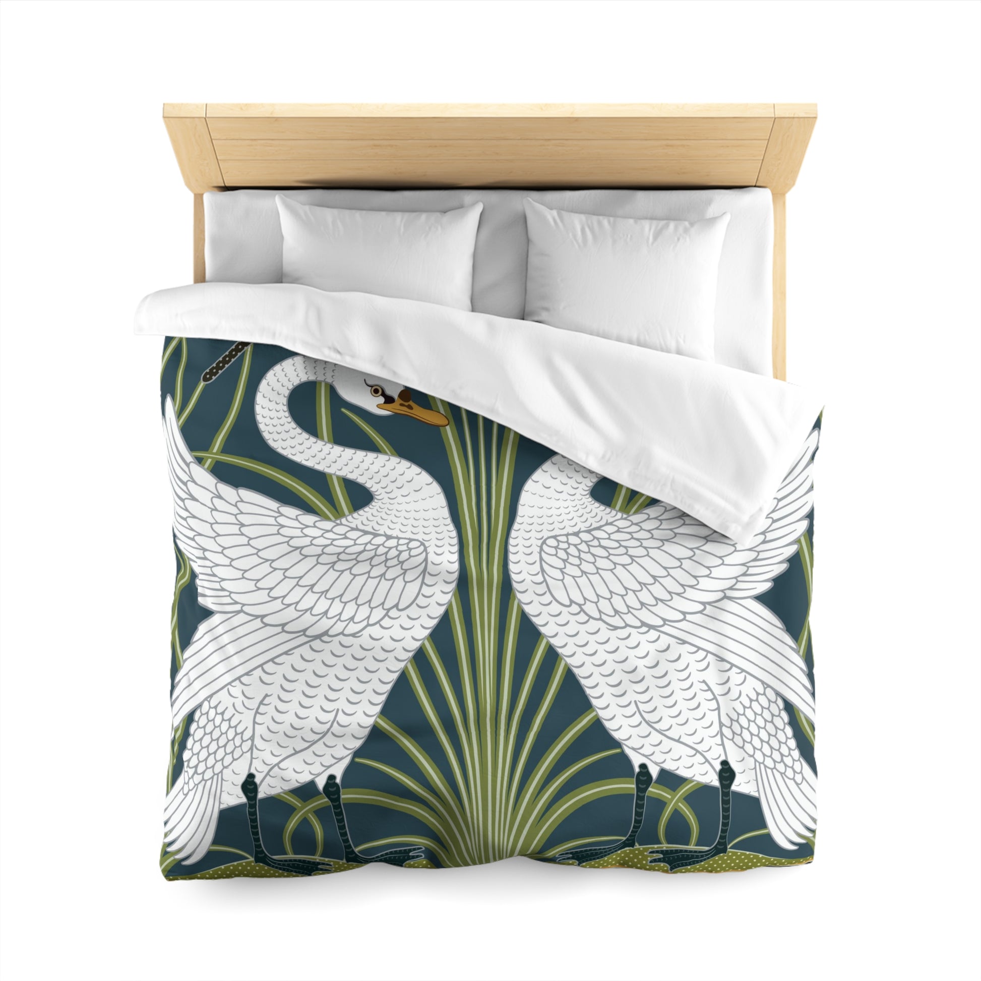 A duvet cover with a William Morris & Co pattern floral and swan pattern, displayed on a bed with pillows.