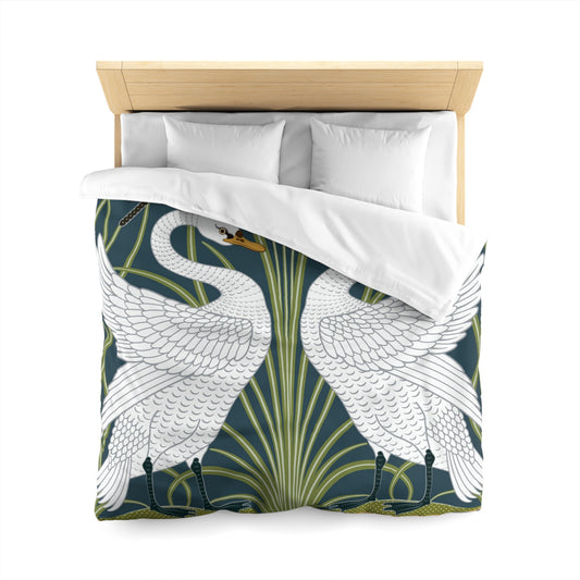 A duvet cover with a William Morris & Co pattern floral and swan pattern, displayed on a bed with pillows.