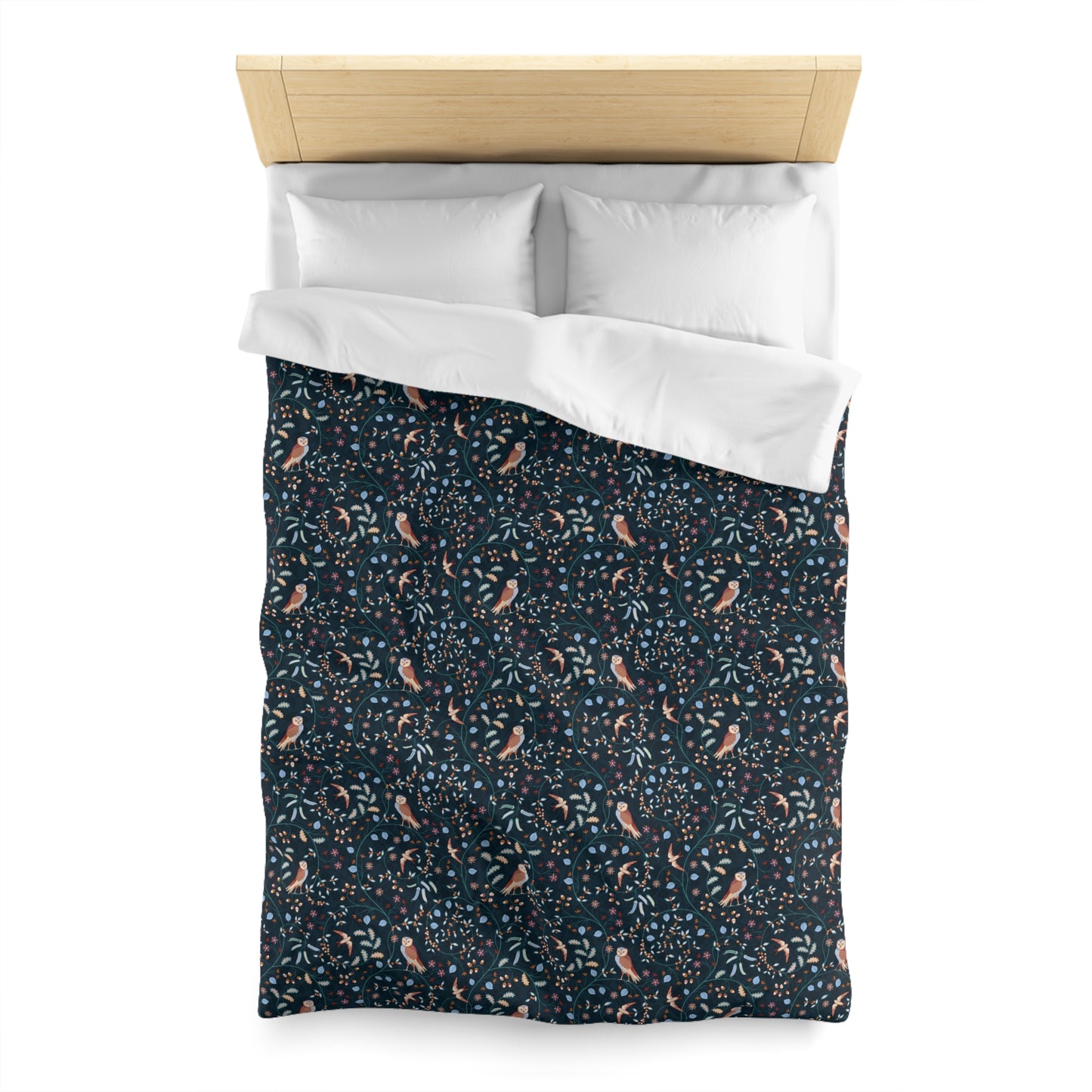 Patterned duvet cover with white pillow shams on a bed with wooden headboard.