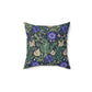 A square-shaped faux suede cushion with a floral William Morris & Co pattern featuring blue flowers and green leaves on a dark background called Compton.