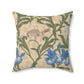 A square-shaped throw pillow with an all-over print featuring a bird, floral William Morris & Co patterns, and blue irises on a beige background.