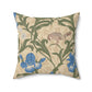 A square-shaped throw pillow with an all-over print featuring a bird, floral William Morris & Co patterns, and blue irises on a beige background.