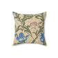A square-shaped throw pillow with an all-over print featuring a bird, floral William Morris & Co patterns, and blue irises on a beige background.