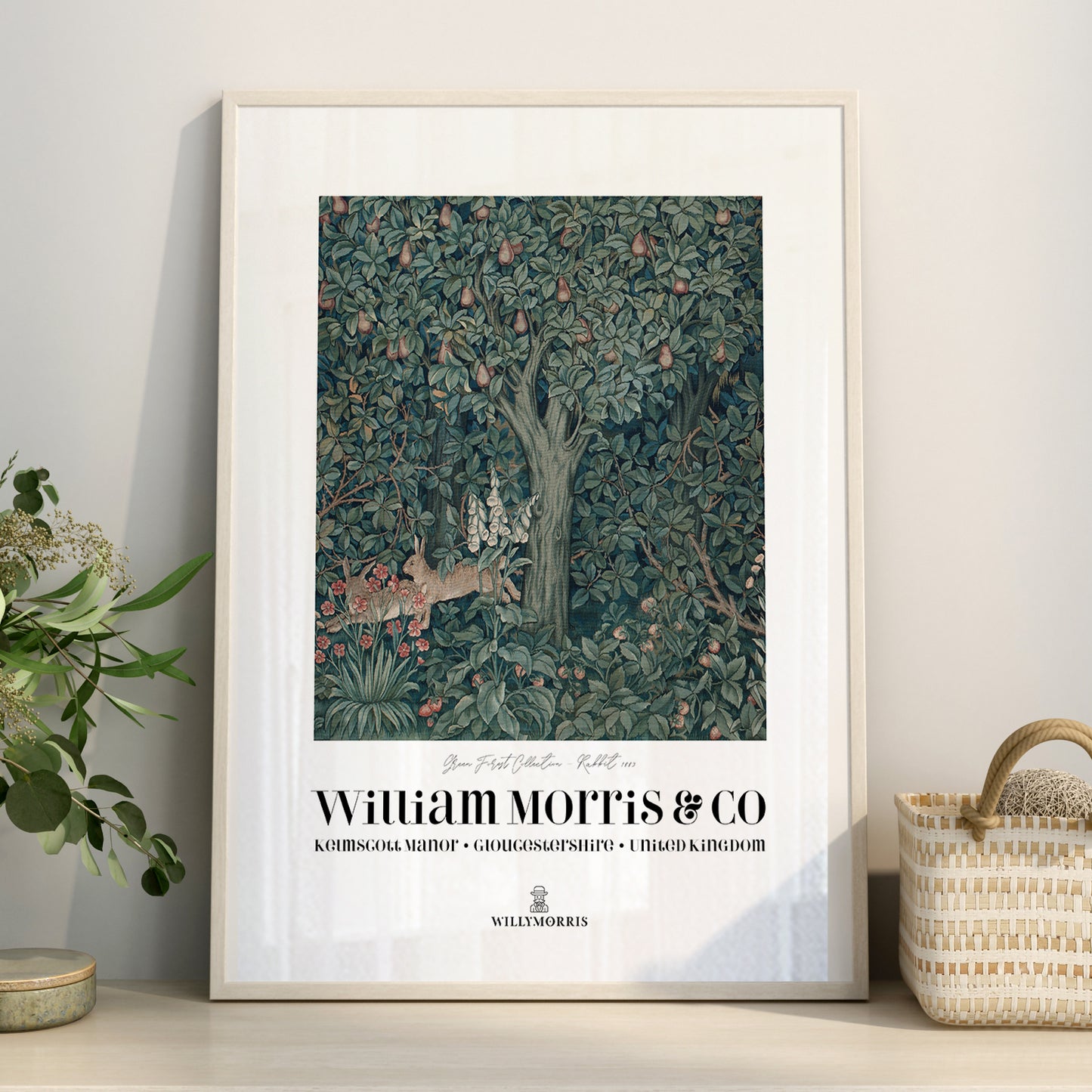 Framed artwork with a tree and animals design by William Morris & Co on a wall.