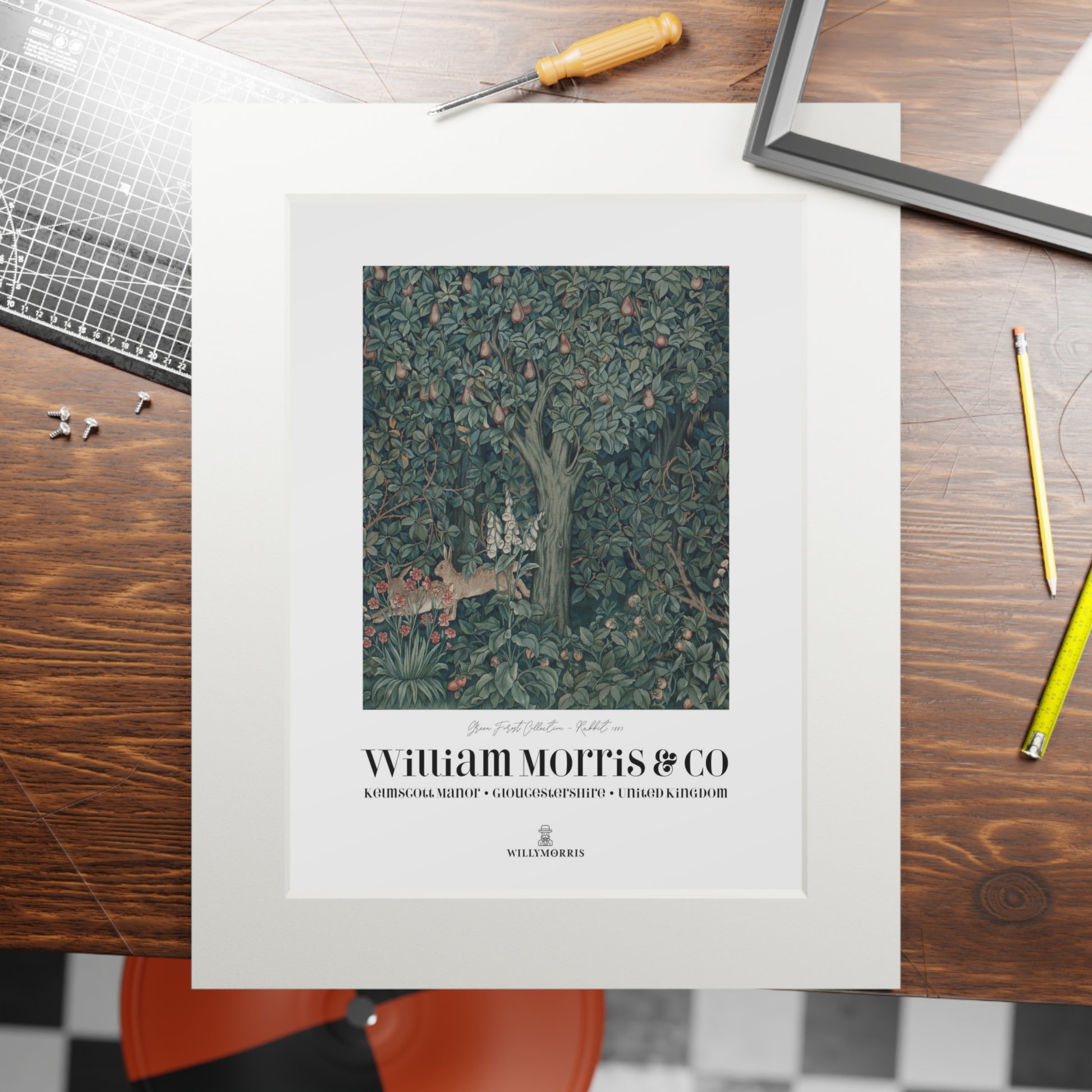 Framed artwork with 'William Morris & Co' branding on a wooden table.