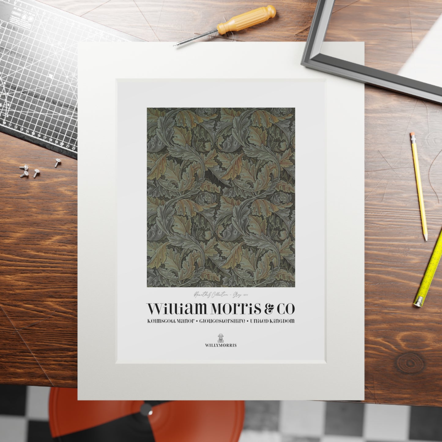 Framed patterned print with 'William Morris & Co' branding on a wooden table.