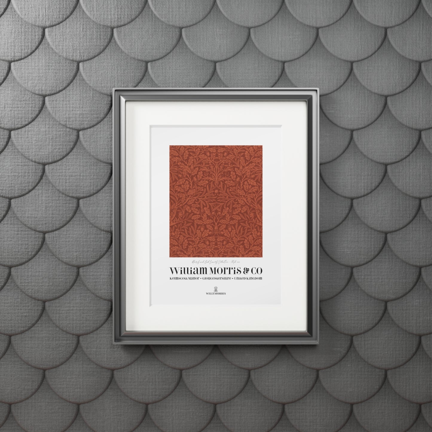 Framed artwork with a red pattern and text on a textured gray wall.