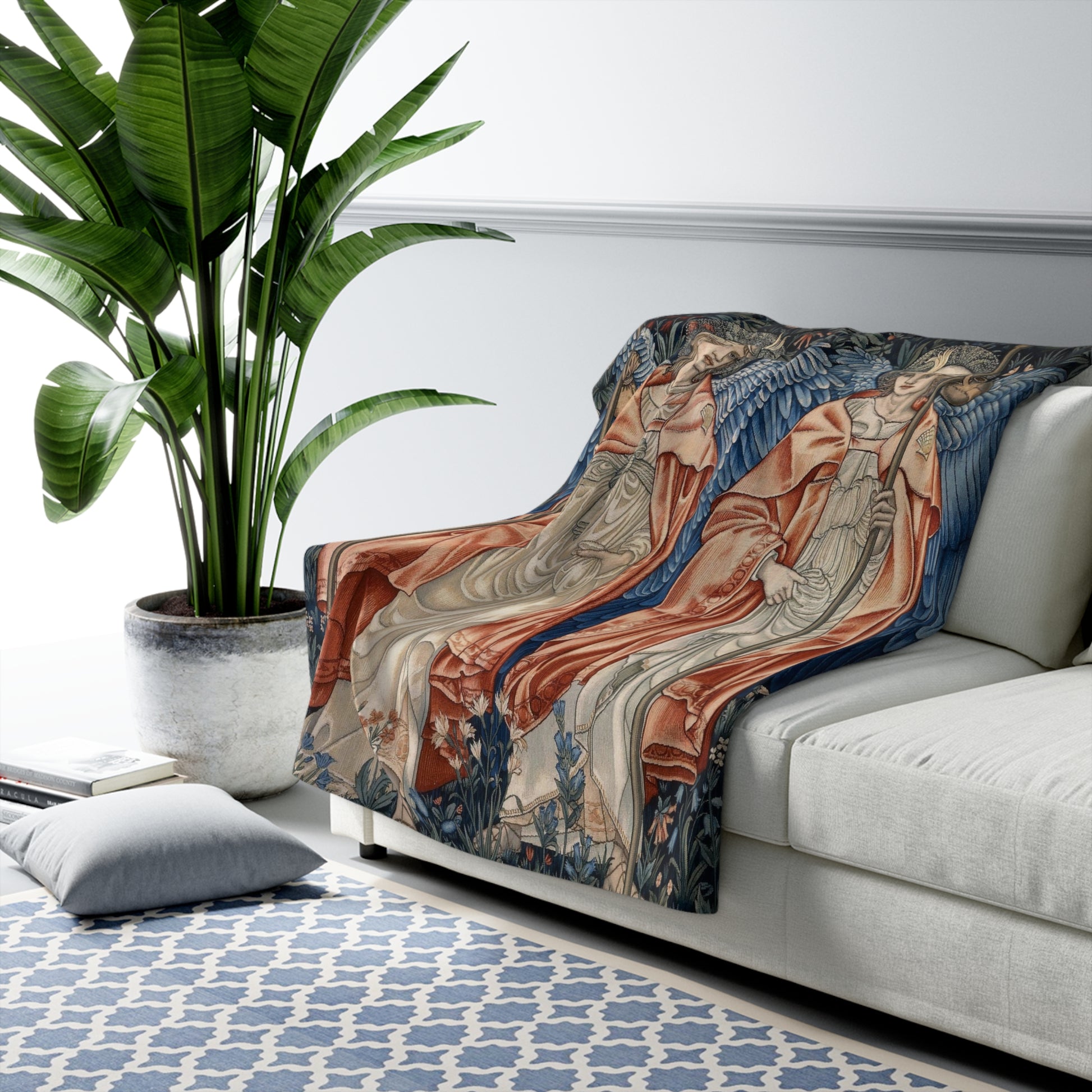 A Sherpa fleece blanket with a floral and angelic pattern inspired by William Morris' work.