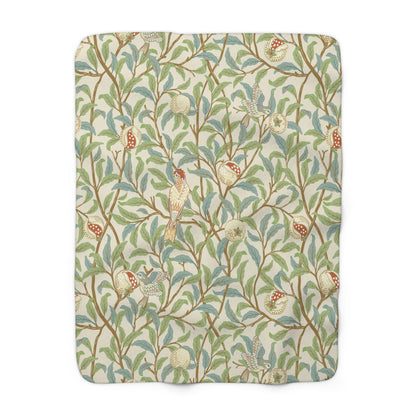 A plush fleece blanket with a floral William Morris & Co pattern featuring birds and pomegranates, predominantly in green tones.