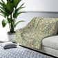 A plush fleece blanket with a floral William Morris & Co pattern featuring birds and pomegranates, predominantly in green tones.