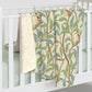A plush fleece blanket with a floral William Morris & Co pattern featuring birds and pomegranates, predominantly in green tones.