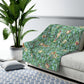 A Sherpa fleece blanket with an all-over print of birds and pomegranate fruits inspired by William Morris & Co on a blue background.