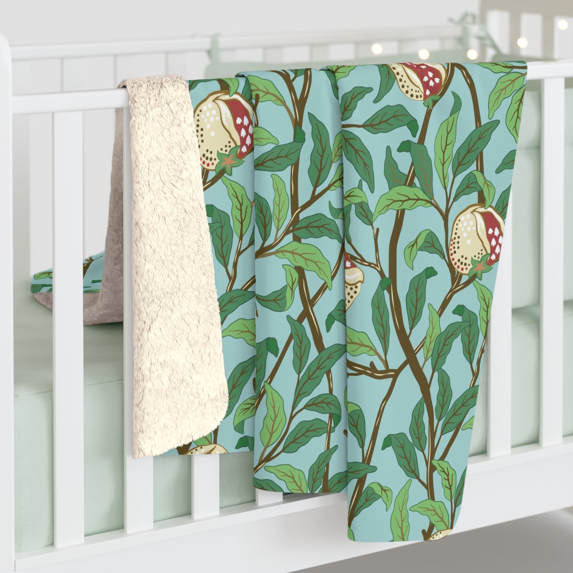 A Sherpa fleece blanket with an all-over print of birds and pomegranate fruits inspired by William Morris & Co on a blue background.