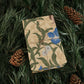Gifts wrapped in decorative wrapping paper with William Morris & Co floral patterns, placed on a table alongside a roll of paper, scissors, and tags.
